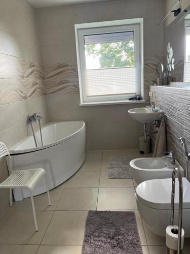 a white bathroom with a tub and a sink at FAMILY HOUSE MARUPE in Mārupe