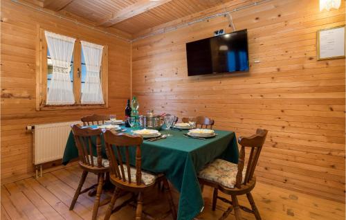a dining room with a table and a tv on a wall at Amazing Home In Podstene in Kupa