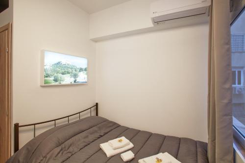 a bedroom with a bed with two towels at ATHENS COMMERCIAL in Athens