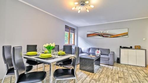 a dining room with a table and chairs and a couch at Leśny Dom, Sun & Snow in Karpacz