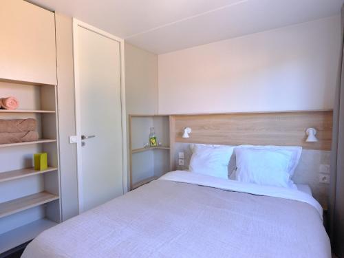 una camera da letto con un grande letto bianco e scaffali di Blendin Retreat Agde a Le Grau-dʼAgde