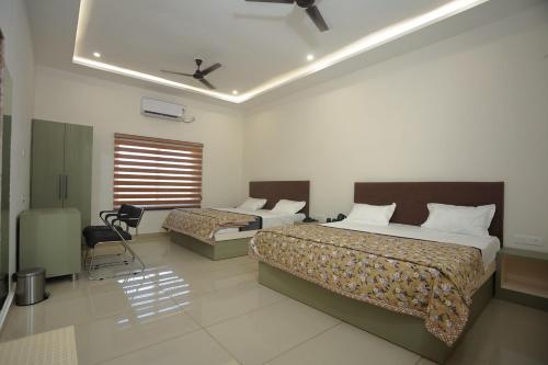 a hotel room with two beds and a window at Prem Sadan, Pandokhar Sarkar Dham in Indargarh