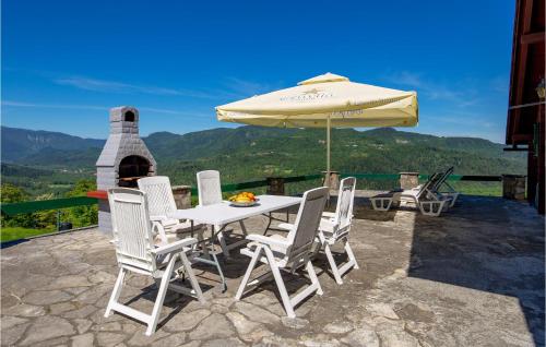 a table and chairs with an umbrella on a patio at Amazing Home In Podstene in Kupa