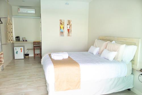 a bedroom with a large white bed with white pillows at Bella Gamboa Casa de Praia - Gamboa, Morro de São Paulo - in Gamboa