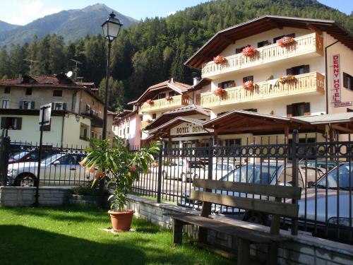 un edificio con coches estacionados frente a él en Hotel Denny en Pinzolo