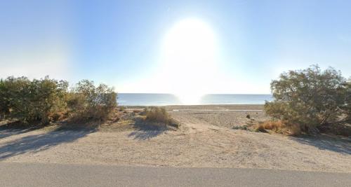 a dirt road with trees and the ocean in the background at 12 senses faliraki sea view in Faliraki
