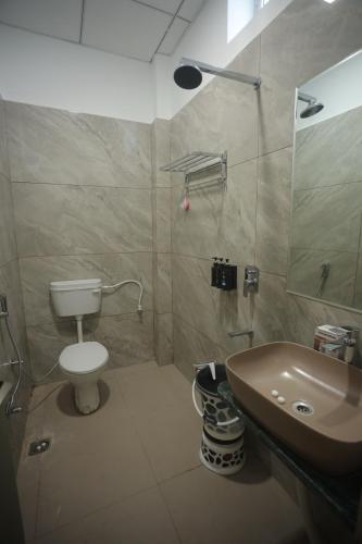 a bathroom with a toilet and a sink at Prem Sadan, Pandokhar Sarkar Dham in Indargarh