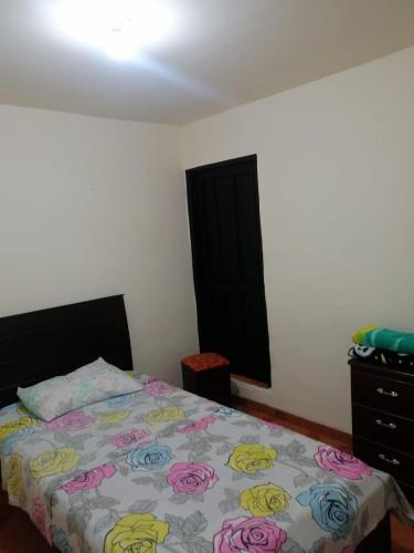 a bedroom with a bed and a dresser at Casa Rosas in Pereira
