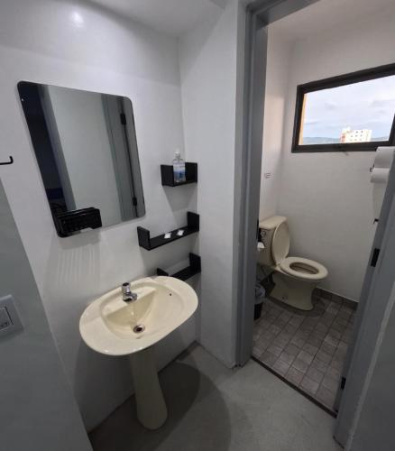 a bathroom with a sink and a toilet at HAUSHostel in Vinhedo