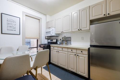a kitchen with white cabinets and a table and chairs at Inspire the vibrant energy of Columbia University in New York