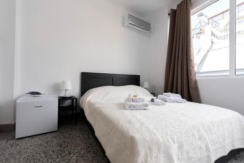 a bedroom with a white bed with towels on it at ATHENS COMMERCIAL in Athens
