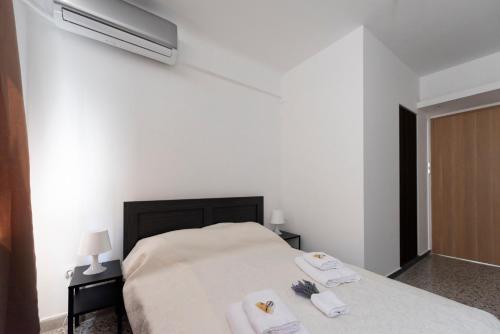 a white bedroom with a bed with towels on it at ATHENS COMMERCIAL in Athens