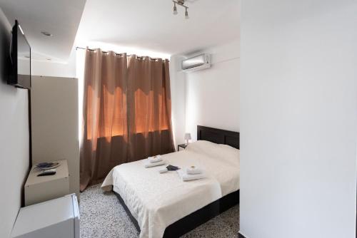 a small bedroom with a bed and a window at ATHENS COMMERCIAL in Athens