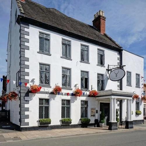 a white building with a clock on the side of it at The Hart Uttoxeter in Uttoxeter