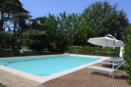 a swimming pool with a chair and an umbrella at Relais Felciaino B&B in Bolgheri