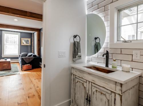 a kitchen with a sink and a mirror at The Old Bell Tavern - Luxury Meets History in New Gloucester