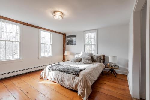 a white bedroom with a bed and two windows at The Old Bell Tavern - Luxury Meets History in New Gloucester