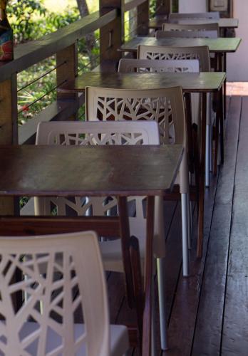 a row of tables and chairs on a porch at Bella Gamboa Casa de Praia - Gamboa, Morro de São Paulo - in Gamboa