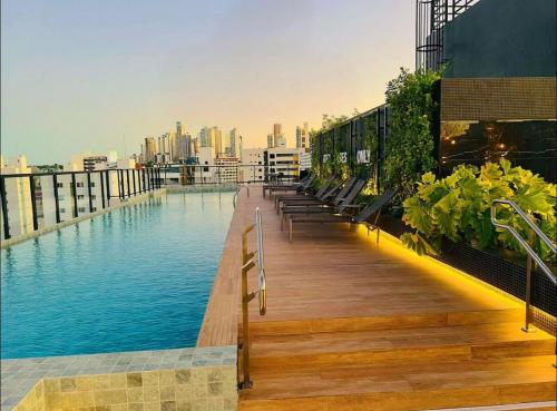 a swimming pool on the roof of a building with a city at Flat Elegante c/ Varanda e Vista Mar - Tambaú in Tambaú