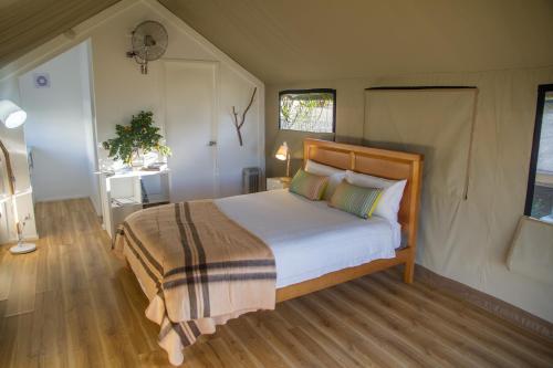 a bedroom with a large bed with a wooden headboard at South Coast Retreat in Greenwell Point