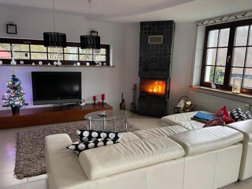 a living room with a white couch and a christmas tree at Willa Solina in Solina