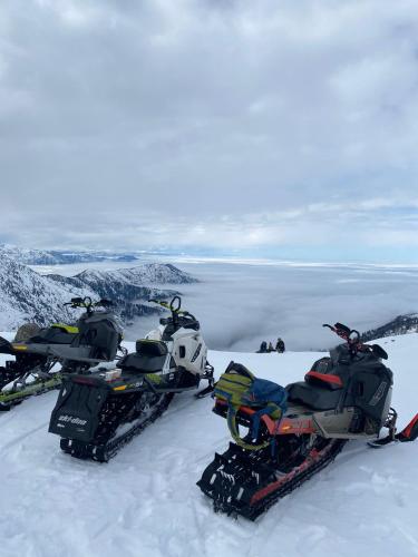 three snowmobiles parked on top of a snowy mountain at Flora Handüzü Resort & Wellness Bungalow Hotel in Rize