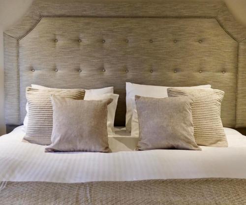 a bedroom with a large bed with white pillows at The Hart Uttoxeter in Uttoxeter