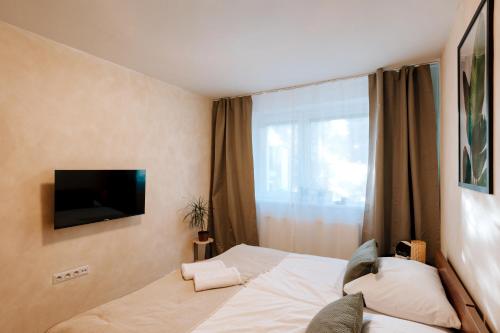 a bedroom with a bed with a television on the wall at Villa KESTA, centrum, free parking in Martin