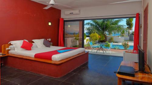 a bedroom with a bed with a view of a patio at Résidence Sarimanok in Nosy Be