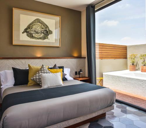 a bedroom with a bed with a view of a tub at Hotel Criol in Querétaro