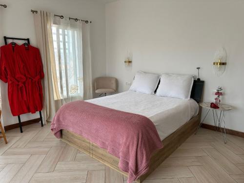 a bedroom with a large bed with a red blanket at Tia Vahine in Ivato