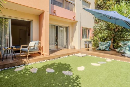 Un patio con un putting green y una sombrilla en Charming 80m for 6 people with garden, en Cros-de-Cagnes