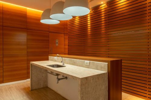 eine Küche mit einem Waschbecken und Holzwänden in der Unterkunft Vista Park Hplus Long Stay in Brasilia