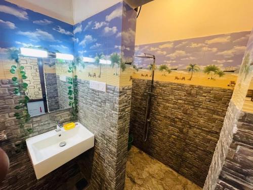a bathroom with a sink and a mural of a beach at Coco CINNAMON HEAVEN in Ahangama Nakanda