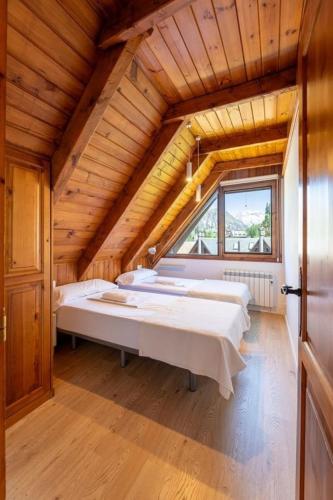 a room with three beds in a wooden house at Las casitas de mache - LAROCA in Cerler