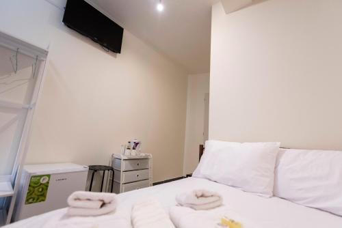 a bedroom with a white bed with towels on it at ATHENS COMMERCIAL in Athens