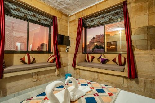 two swans sitting in a room with two windows at Peace & Joy in Jaisalmer