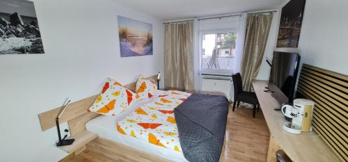 Un dormitorio con una cama y un escritorio con televisión. en Suite in Siegens Oberstadt, en Siegen