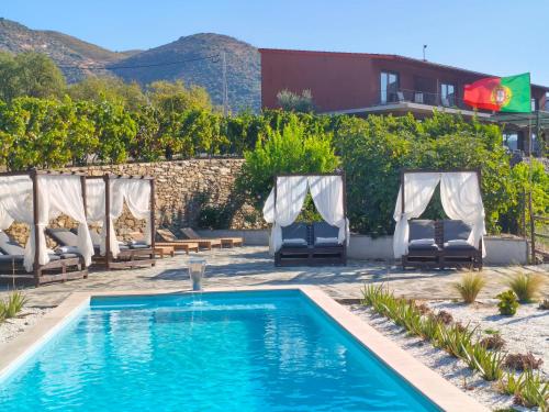 a pool with chaise lounge chairs and a resort at Wine House - Quinta Vale de Carvalho in Torre de Moncorvo