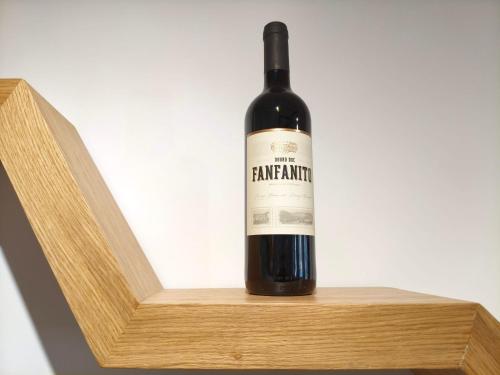 a bottle of wine sitting on a wooden shelf at Wine House - Quinta Vale de Carvalho in Torre de Moncorvo