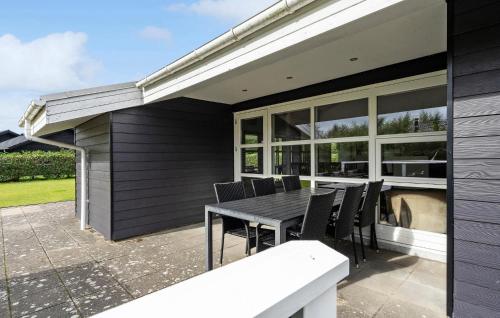 a patio with a black table and chairs at Nice Home In Tarm With Sauna in Højsand