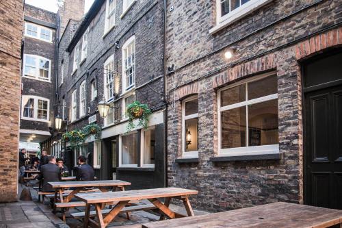 a row of wooden tables in front of a building at St Christopher's Inn London Bridge - The Inn in London