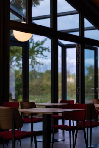 Una mesa y sillas en una habitación con ventanas. en Agriturismo Il Ceraseto da Tomasi, en San Biagio di Callalta