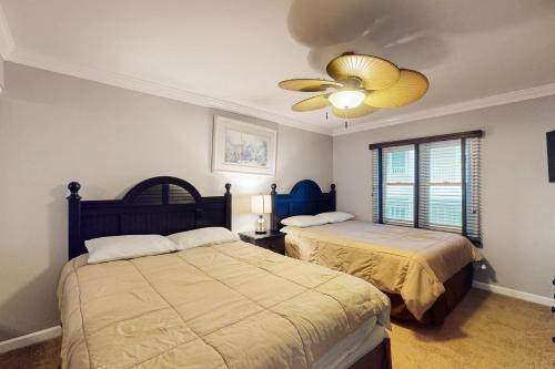 a bedroom with two beds and a ceiling fan at White Marlin 208B in Ocean City
