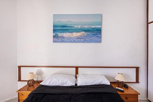 a bedroom with a bed and two lamps and a painting at Barra Palace Hotel in Rio de Janeiro