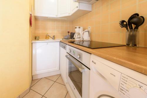 a small kitchen with a sink and a dishwasher at Maison en Pierre avec Jardin 4 Voyageurs in Luré