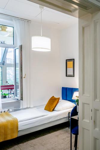 a white bedroom with a bed and a window at Elisabeth Old Town in Bratislava