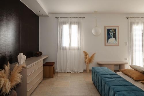 a bedroom with a bed and a blue couch at ZELION VILLA in Stelida