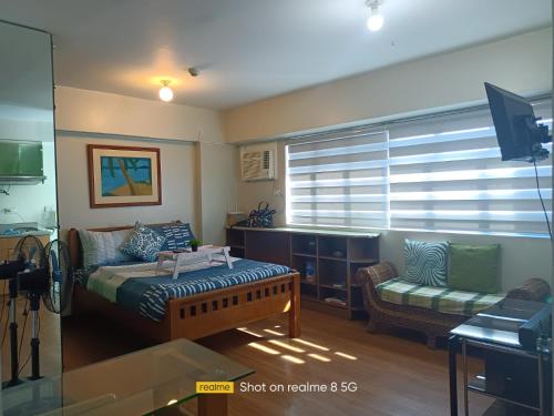 a room with a bed and a couch and a window at WestParc Cedar Alabang in Manila