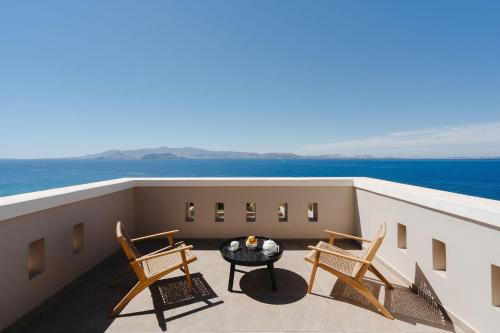 a balcony with two chairs and a table on a ship at ZELION VILLA in Stelida